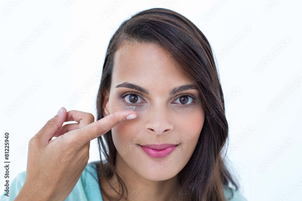 Beautiful woman applying contact lens Beautiful woman applying contact lens