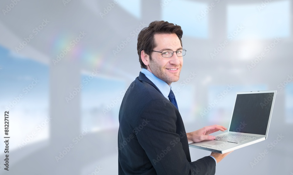 Composite image of smiling businessman using a laptop Composite image of smiling businessman using a laptop