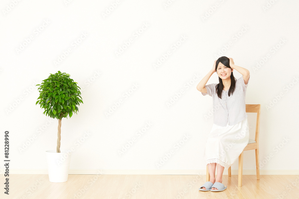 部屋で頭を抱える女性
