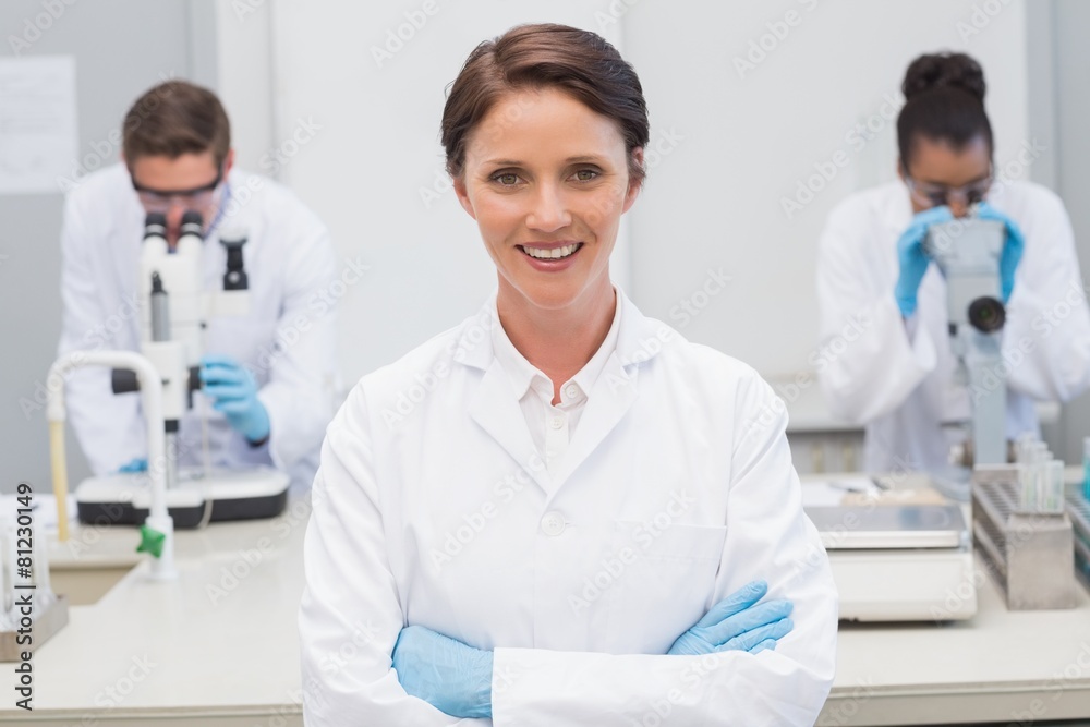 Happy scientist smiling at camera with arms crossed Happy scientist smiling at camera with arms crossed