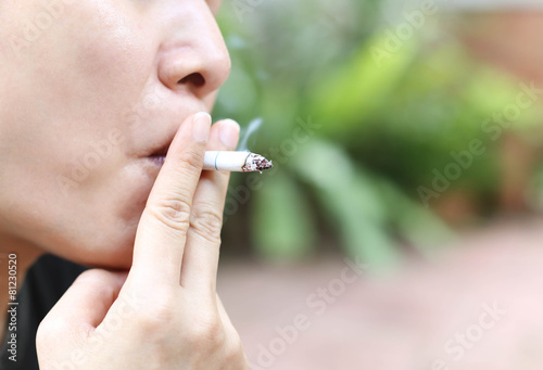 health care concept woman smokes a cigarette outdoors photo