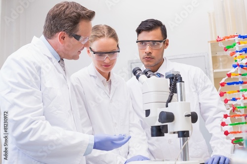 Scientists working attentively with microscope