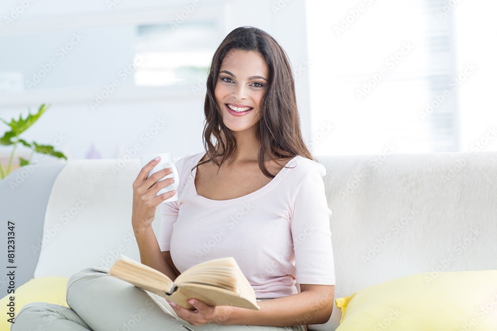 Beautiful brunette holding mug and reading a book Beautiful brunette holding mug and reading a book