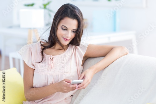 Foto Brunette using her phone on couch