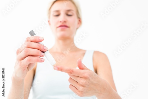 Smiling woman testing her blood glucose level