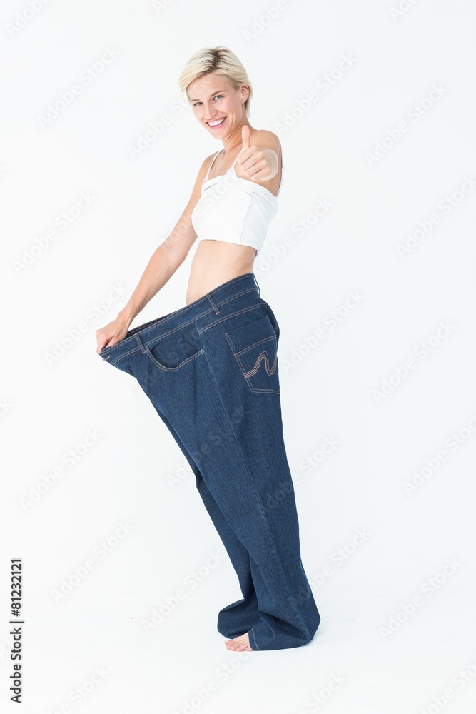 Blonde wearing too large pants with the thumb up Blonde wearing too large pants with the thumb up
