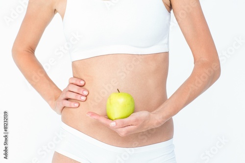 Woman holding an apple in front of her belly