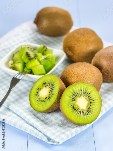 Group of kiwi fruit (cut up and whole) on the wooden table