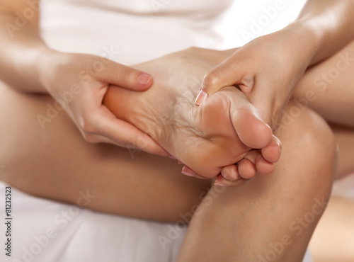 Canvas Print woman massaging her tired feet