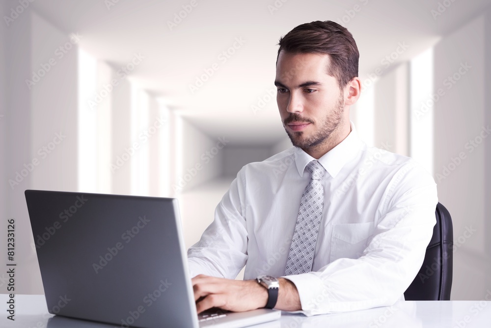 Composite image of cheerful businessman using laptop at desk Composite image of cheerful businessman using laptop at desk