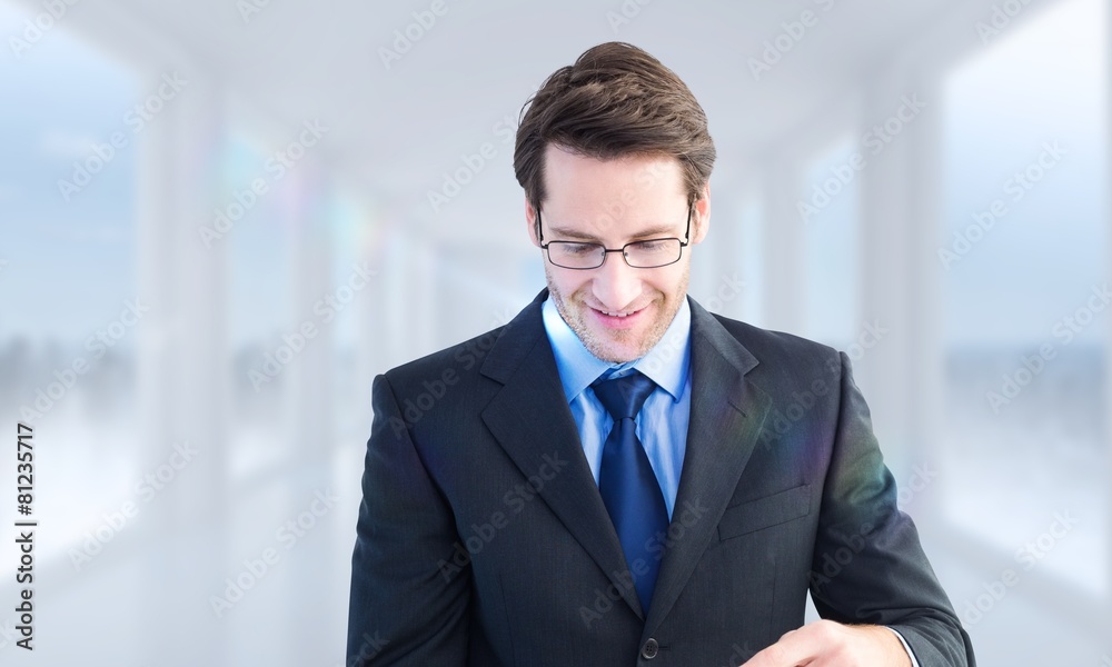Composite image of businessman standing while using a tablet pc Composite image of businessman standing while using a tablet pc
