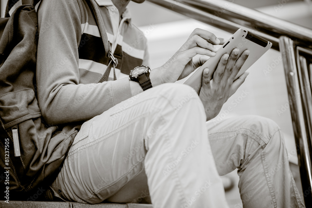 a student using a tablet on stairs a student using a tablet on stairs