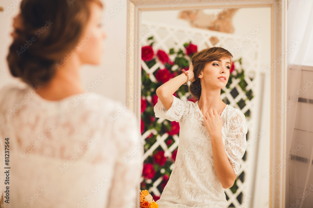portrait of a model posing in the mirror. looking away