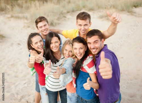 group of happy friends having fun on beach © Syda Productions