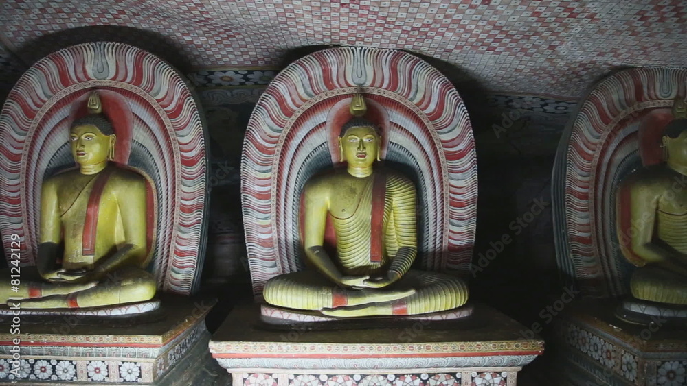 DAMBULLA, SRI LANKA - FEBRUARY 2014: The view of three sitting Buddhas at the Golden Temple of Dambulla. The Golden Temple of Dambulla is a World Heritage Site in Sri Lanka.
