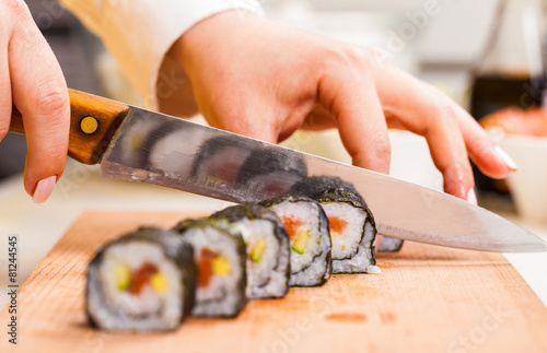 Foto knife in hand cuts the roll closeup