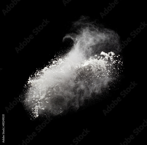 Freeze motion of white powder exploding, isolated on black