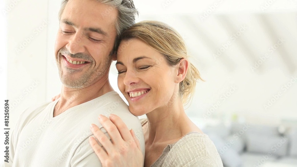 Mature couple embracing each other at home