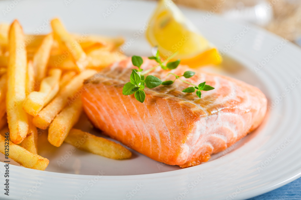 Homemade french fries with salmon served on plate Homemade french fries with salmon served on plate