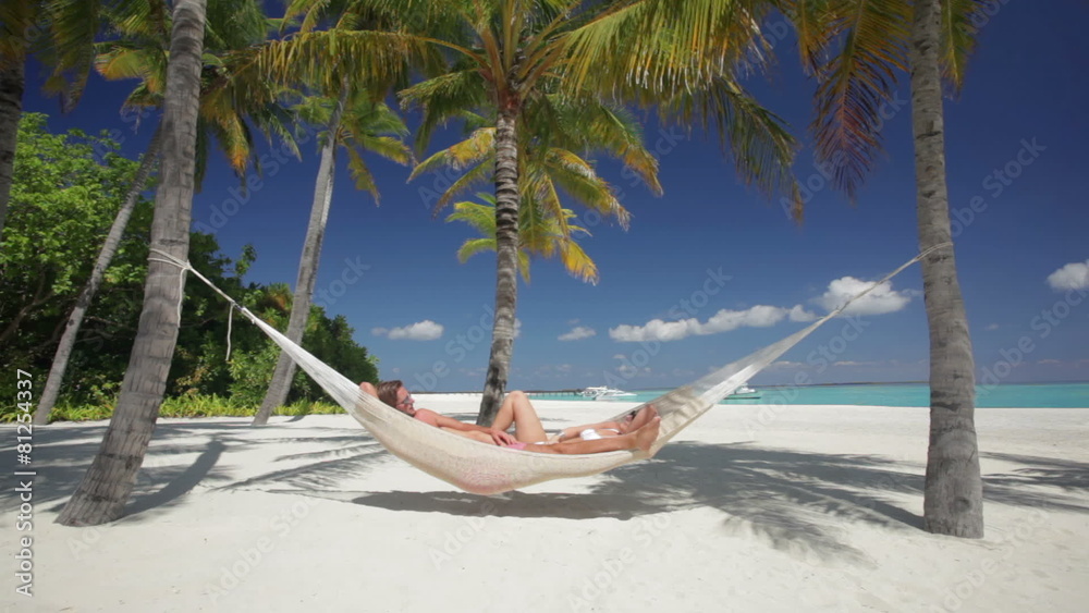 man and woman in hammock on tropical island