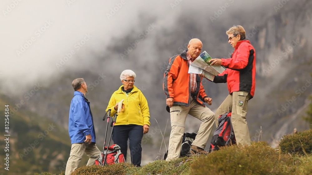 four senior hikers looking at map wide four senior hikers looking at map wide