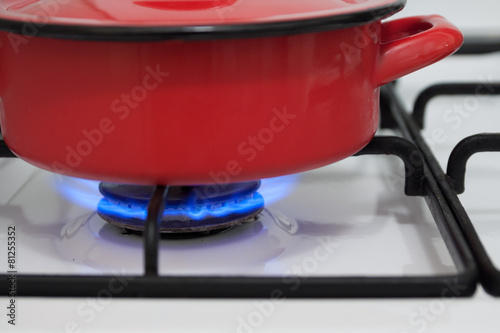 Red pan on the gas stove burning flame
