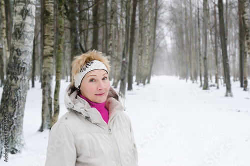 Portrait of a middle-aged woman on the background of a winter al