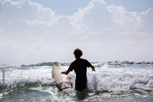 unidentified man surfing in the sea