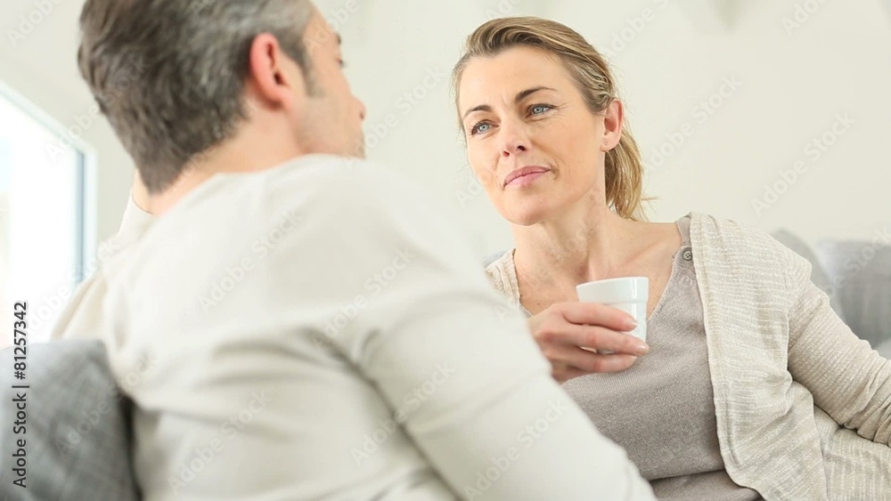 Mature couple relaxing in sofa and having a talk Mature couple relaxing in sofa and having a talk
