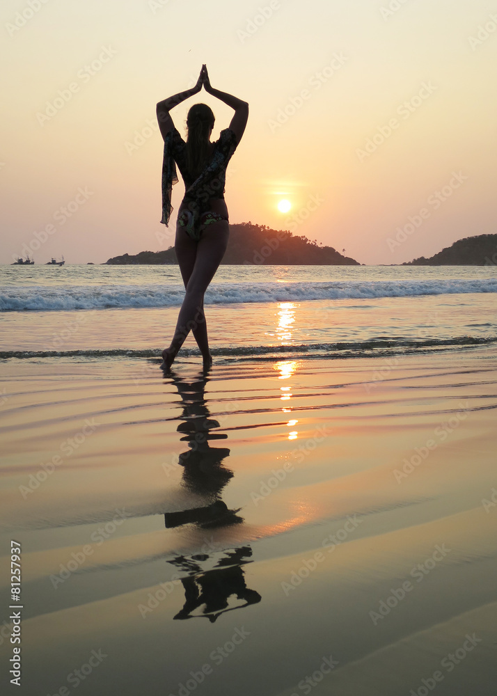 Young woman meditating on Palolem beach. South Goa, India
