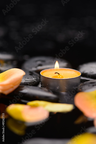 Orange rose petals with candle and therapy stones