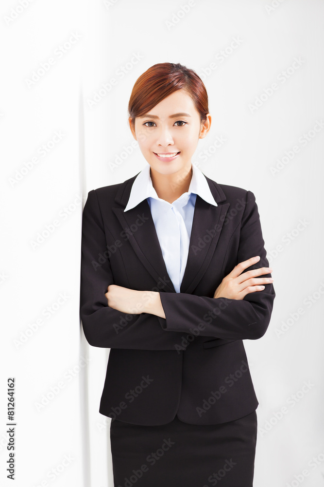 young businesswoman leaning against white wall in office young businesswoman leaning against white wall in office