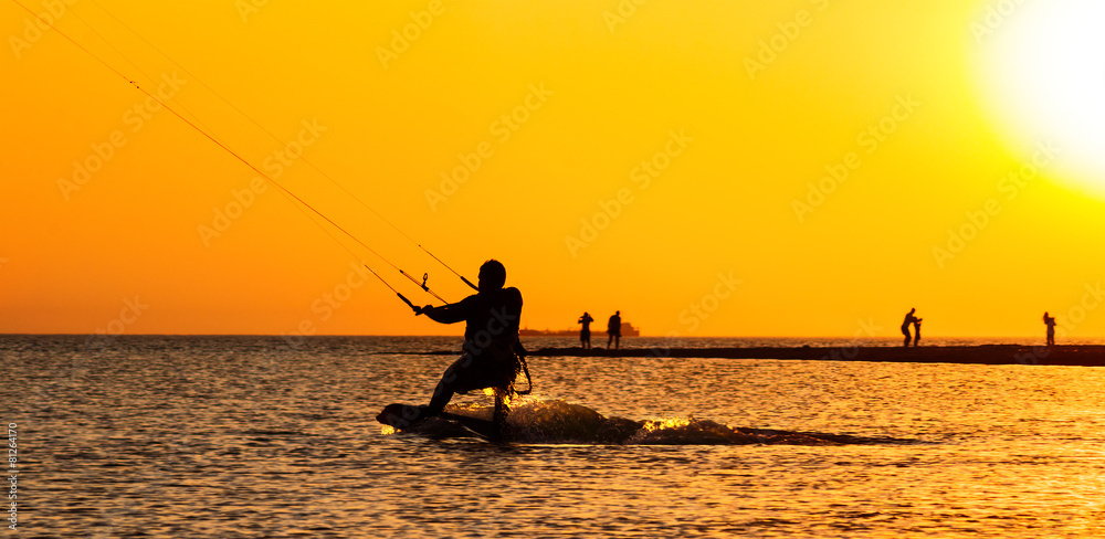 Kite surfing at sunset in the sea
