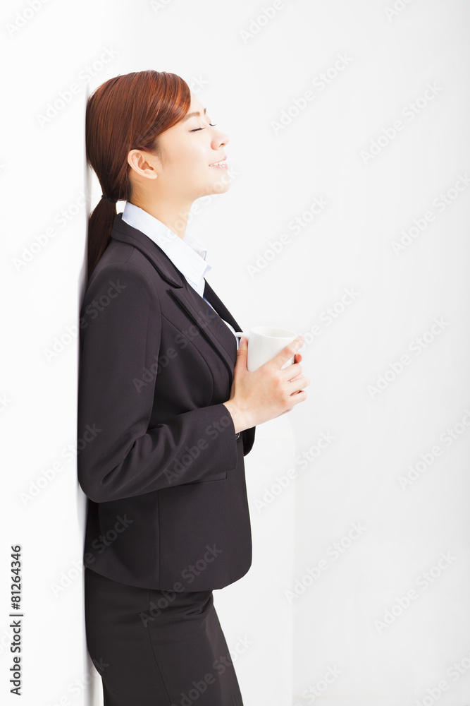 relaxed businesswoman leaning against white wall in office relaxed businesswoman leaning against white wall in office