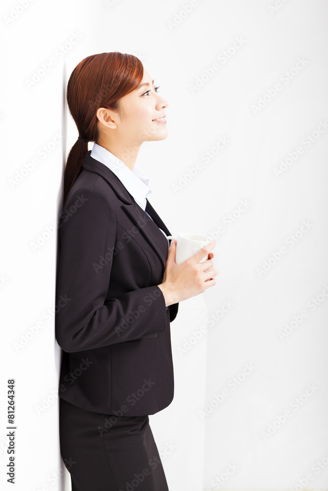 relaxed businesswoman leaning against white wall in office relaxed businesswoman leaning against white wall in office