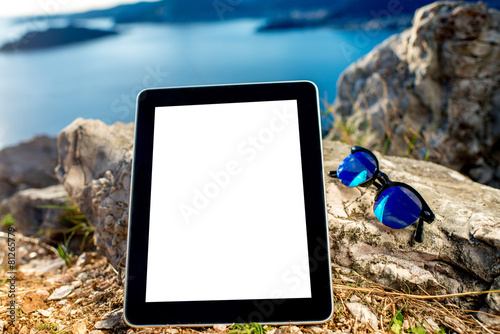 Digital tablet with sunglasses on the mountain