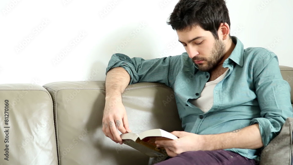 Man sitting in living room reading interesting book Man sitting in living room reading interesting book