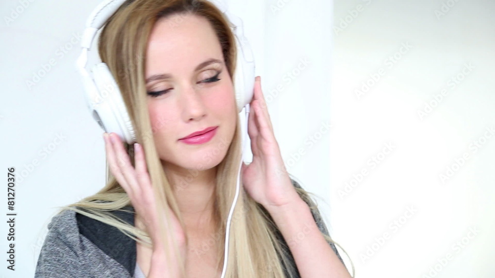 Beautiful young blond woman dancing with white headphones Beautiful young blond woman dancing with white headphones
