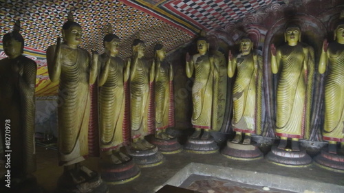 DAMBULLA, SRI LANKA - FEBRUARY 2014: The view of standing Buddhas at the Golden Temple of Dambulla. The Golden Temple of Dambulla is a World Heritage Site in Sri Lanka.