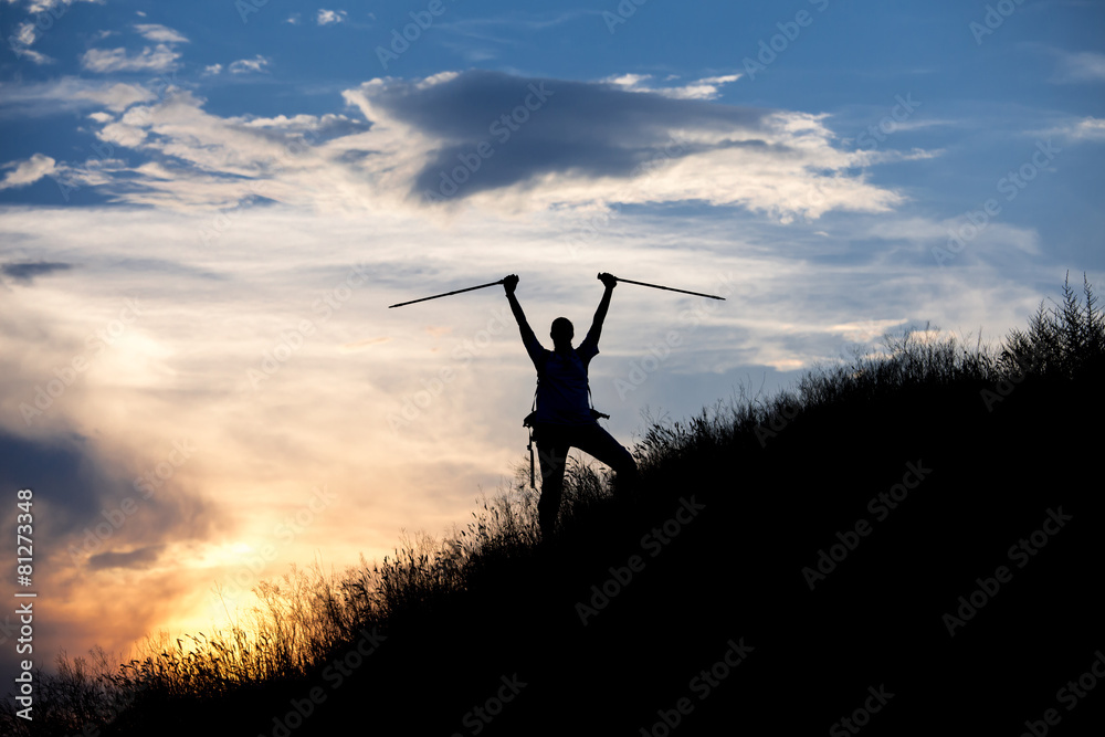 Female hiker silhouette with massive clouds on the background