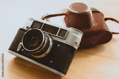 Toned photo of retro camera with brown leather case