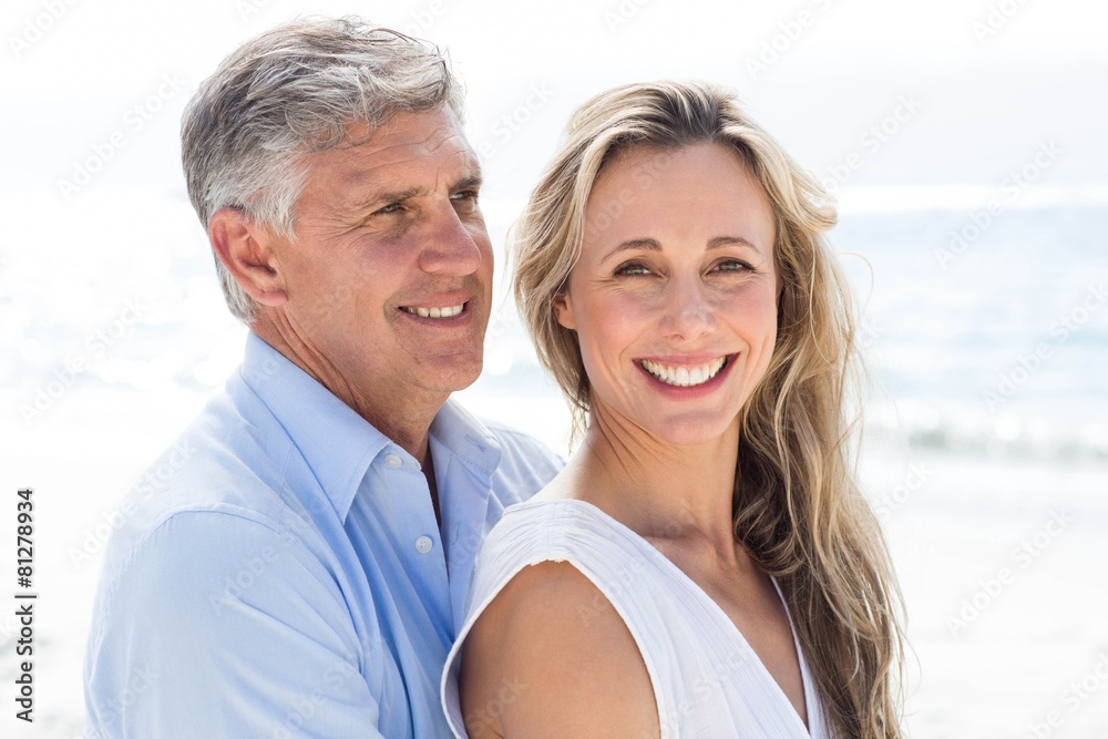Happy couple standing by the sea and hugging each other Happy couple standing by the sea and hugging each other