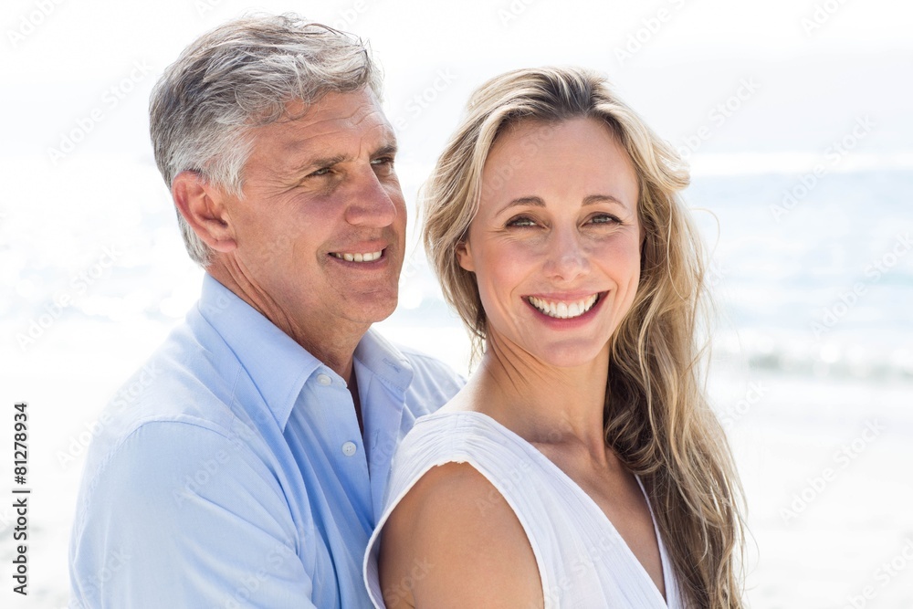 Happy couple standing by the sea and hugging each other