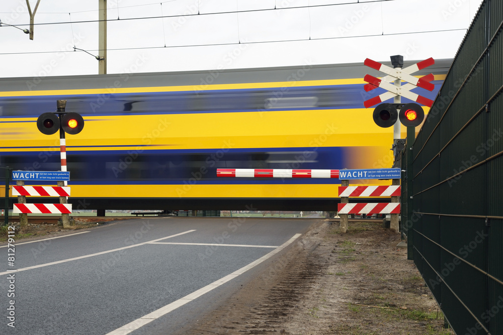 Naklejka premium double deck passenger train at railroad crossing