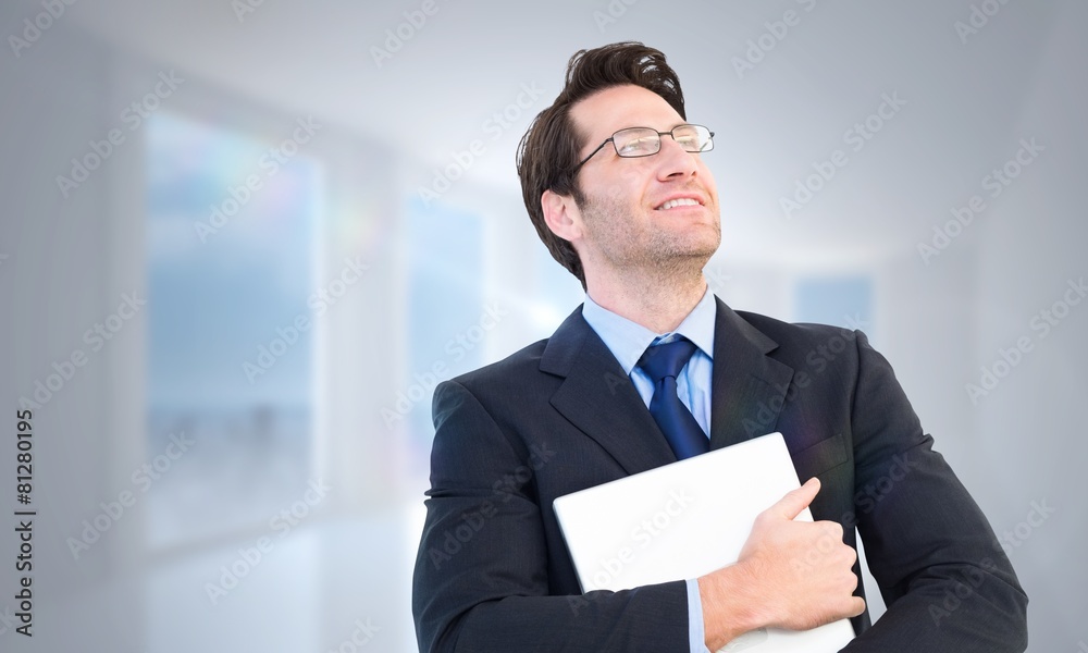 Composite image of handsome businessman holding his laptop Composite image of handsome businessman holding his laptop