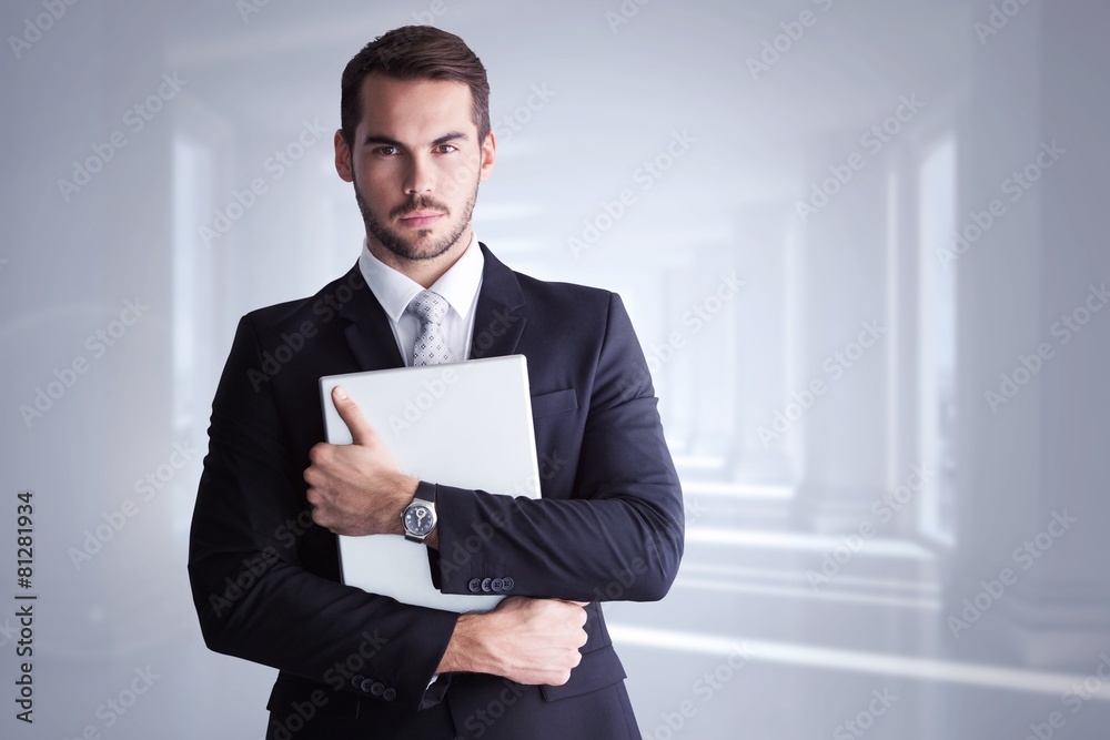 Composite image of businessman in suit posing with his laptop Composite image of businessman in suit posing with his laptop