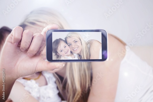 Composite image of hand holding smartphone showing