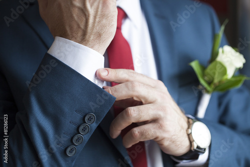 Vászonkép Groom with watch and buttonhole corrects  suit
