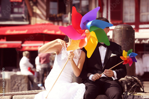 Bride and groom playing with windmill propeller