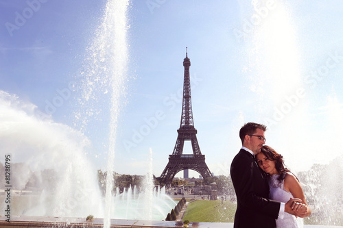 Bride and groom hugging at fountain in Paris